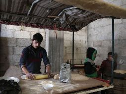Un joven sirio prepara pan dentro de uno de los refugios habilitados para los civiles que huyen de la zona. AFP/A. Eassa