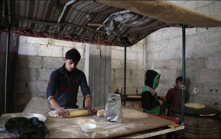 Un joven sirio prepara pan dentro de uno de los refugios habilitados para los civiles que huyen de la zona. AFP/A. Eassa