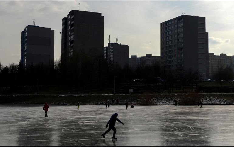 Varias personas patinan sobre un lago congelado en Praga. AFP/M. Cizek