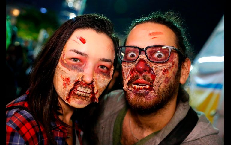 Una pareja de zombies se divierte en las calles. AFP / J. Guez