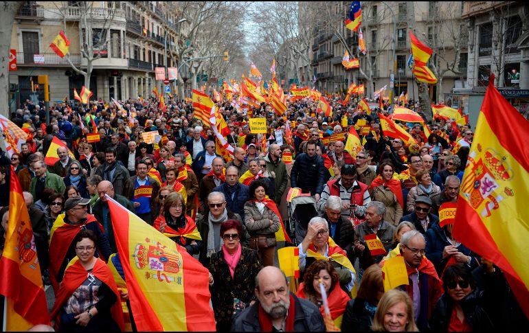 Habitantes levantan banderas españolas durante una manifestación a favor de la unidad en Barcelona. AFP/J. Lago