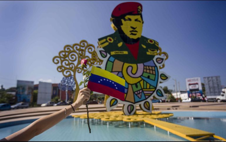 Una joven sostiene una bandera de Venezuela y una flor frente al monumento en honor al ex presidente venezolano Hugo Chávez, en Managua, Nicaragua, en el marco del quinto aniversario de su fallecimiento. EFE/J.Torres