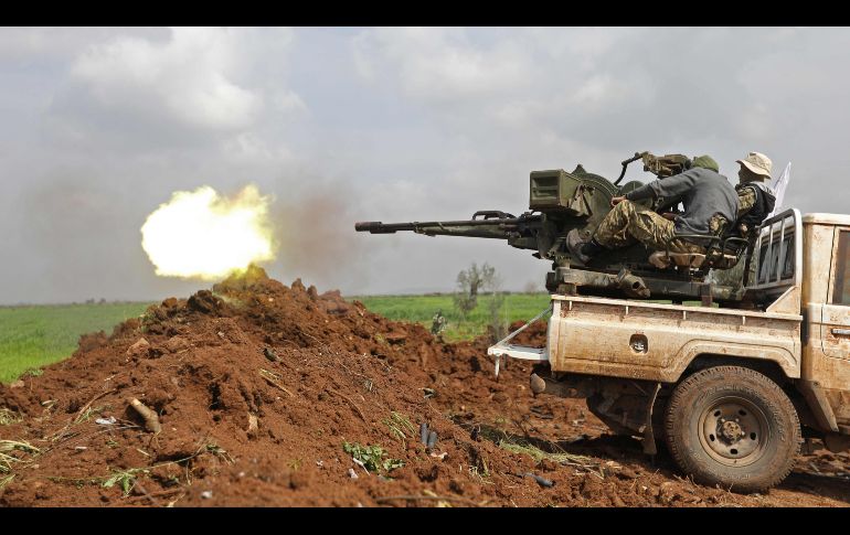 Combatientes respaldados por Turquía disparan un arma antiaérea durante una batalla contra kurdos en Jandairis, Siria, cerca de la frontera con Turquía. AFP/O. Haj Kadour