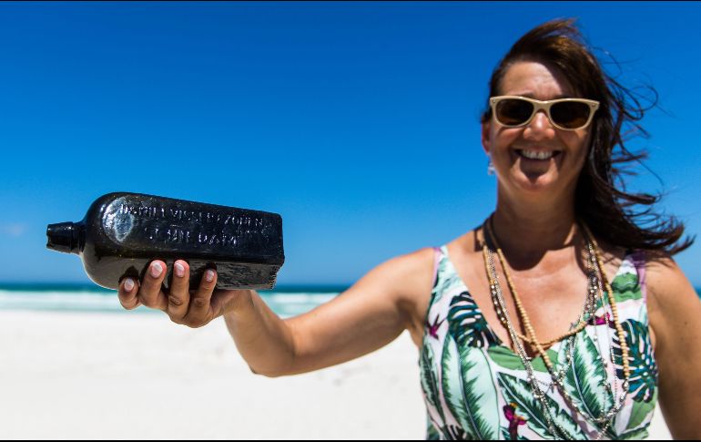 Tonya Illman sostiene la botella que encontró en la arena de una playa de Wedge Island. AFP/Cortesía de Kym Illman