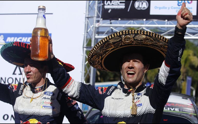 El piloto francés Sebastien Ogier (d) y el copiloto Julien Ingrassia celebran el triunfo en el Rally México, en León, Guanajuato. AFP/U. Ruiz