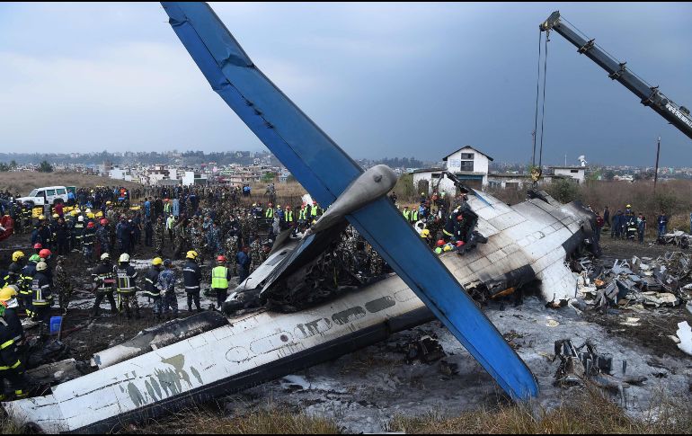 Un avión procedente de Dacca tras estrellarse este lunes con 71 personas a bordo cerca del aeropuerto de Katmandú, en Nepal. El accidente dejó al menos 49 muertos y 22 heridos. AFP/P. Mathema