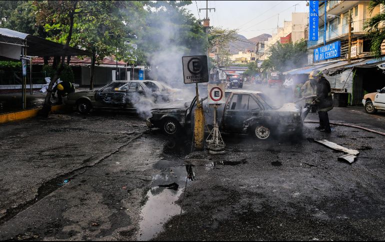 Elementos policiales y de bomberos apagan vehículos incendiados por desconocidos en Acapulco, Guerrero. EFE/D. Guzmán