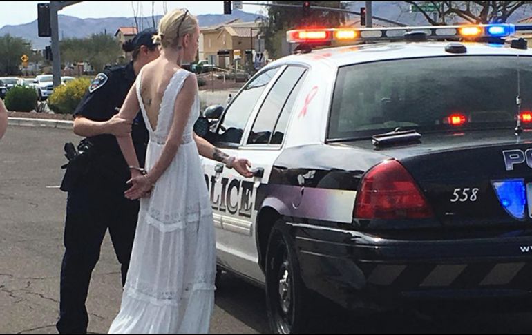 Amber Young llevaba puesto su vestido de novia cuando fue esposada y colocada dentro de un auto patrulla. AP / Marana Police Department