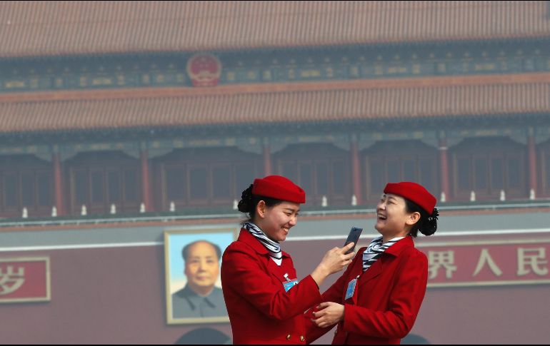 Edecanes de la sesión del Congreso Nacional del Pueblo toman fotos para el recuerdo en la plaza Tiananmen en Pekín, China. AP/A. Wong