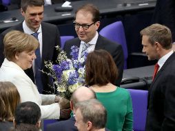 La canciller alemana, Angela Merkel (i), recibe flores tras ser elegida próxima canciller alemana en el Bundestag. EFE/O. Messinger