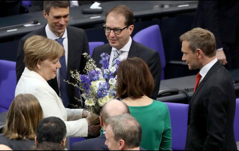 La canciller alemana, Angela Merkel (i), recibe flores tras ser elegida próxima canciller alemana en el Bundestag. EFE/O. Messinger