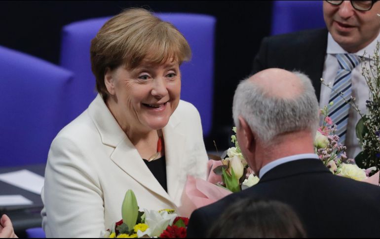 La canciller alemana Angela Merkel recibe felicitaciones tras ser elegida para un cuarto periodo en el cargo, en el parlamento en Berlín. AP/M. Schreiber