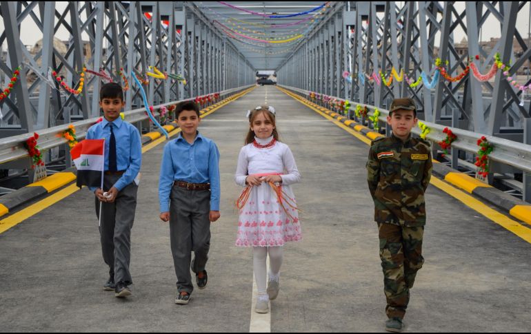 Niños caminan por el puente Nineveh, en la ceremonia de inauguración tras ser reconstruido en la ciudad iraquí de Mosul. AFP/A. Muwafaq
