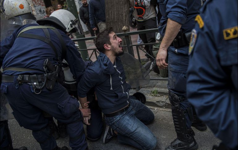 Policías detienen a un manifestante durante una protesta contra la subasta de viviendas en Atenas, Grecia. AFP/A. Tzortzinis