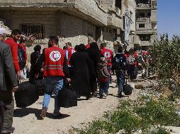 Trabajadores de la Media Luna Roja ayudan en la evacuación de un nuevo grupo de civiles de Guta Oriental a través de un corredor seguro a campamentos de refugiados en la zona rural de Damasco. EFE/SANA