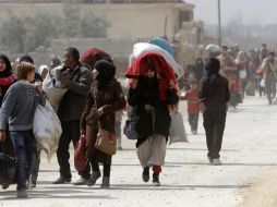 Medios sirios difundieron imágenes de los civiles saliendo a pie, muchos de ellos casi con lo puesto y con muy escasos bultos. AFP/L. Beshara