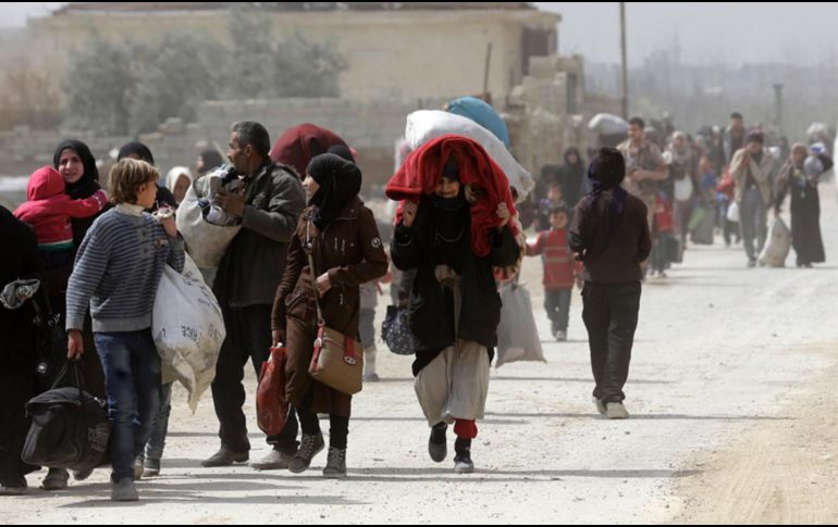 Medios sirios difundieron imágenes de los civiles saliendo a pie, muchos de ellos casi con lo puesto y con muy escasos bultos. AFP/L. Beshara