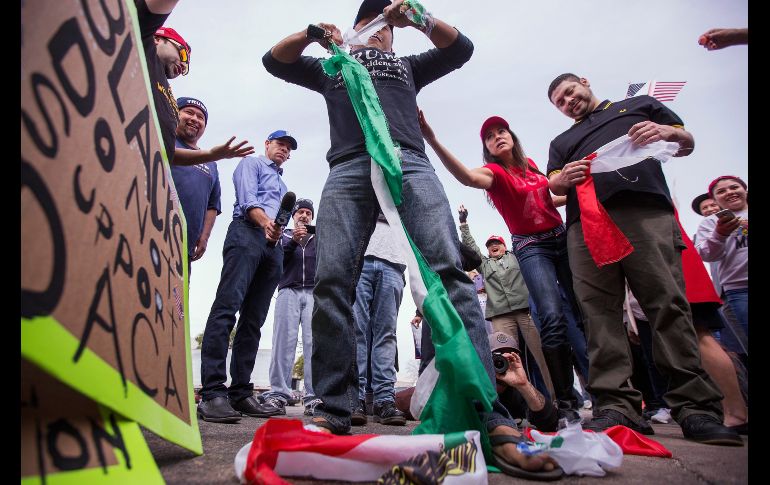 El simpatizante de Trump rompe una bandera mexicana que tomó de una persona que se manifestaba contra el mandatario. AFP/D. Mcnew