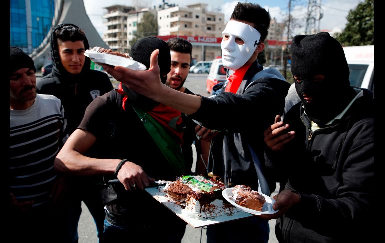 Para todo hay tiempo. Un grupo de manifestantes palestinos parten un pastel para celebrar el cumpleaños de un compañero en medio de una manifestación en la ciudad de Ramala. AFP / A. Momani