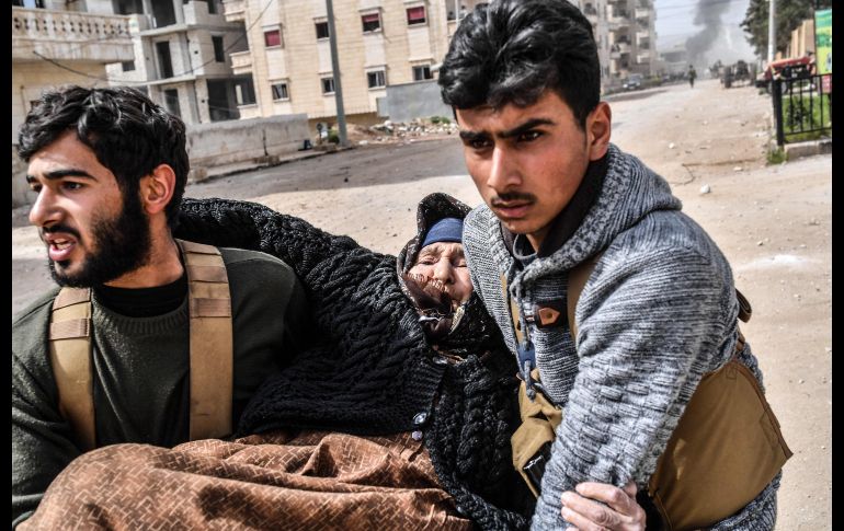 Rebeldes ayudan a evacuar a una mujer tras explosiones. La ciudad de Afrin era el principal objetivo de la ofensiva lanzada el 20 de enero por Turquía contra la milicia kurda Unidades de Protección Popular. AFP/B. Kilic