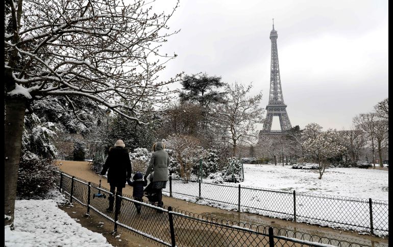 Una familia camina cerca de la torre Eiffel en París. AFP/L. Marin