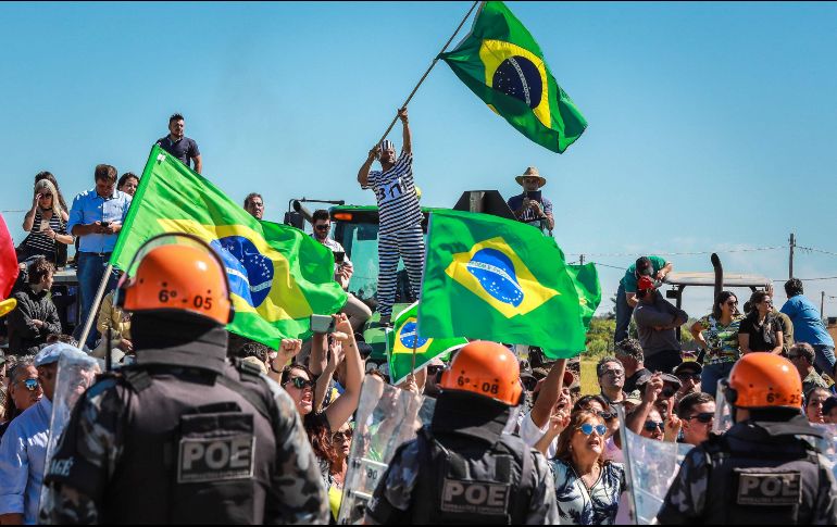Policías antimotines vigilan frente a opositores del ex presidente brasileño Luiz Inacio Lula da Silva en Bage, Brasil. Lula llegó a esta ciudad para una reunión, días antes de que una corte decida si lo envía a prisión por corrupción. AFP/I. Aguiar