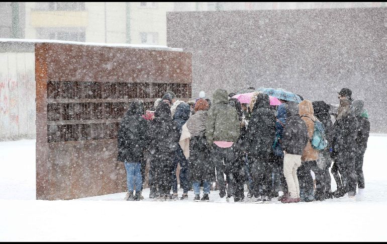 Turistas se reúnen en un punto del Muro de Berlín, Alemania, durante una nevada en plena llegada de la primavera.