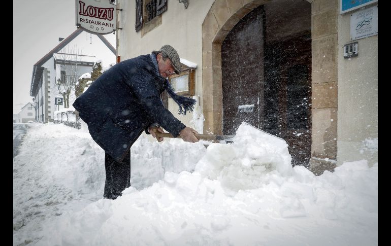 Un habitante de Burguete, España retira nieve de la puerta de su restaurante.