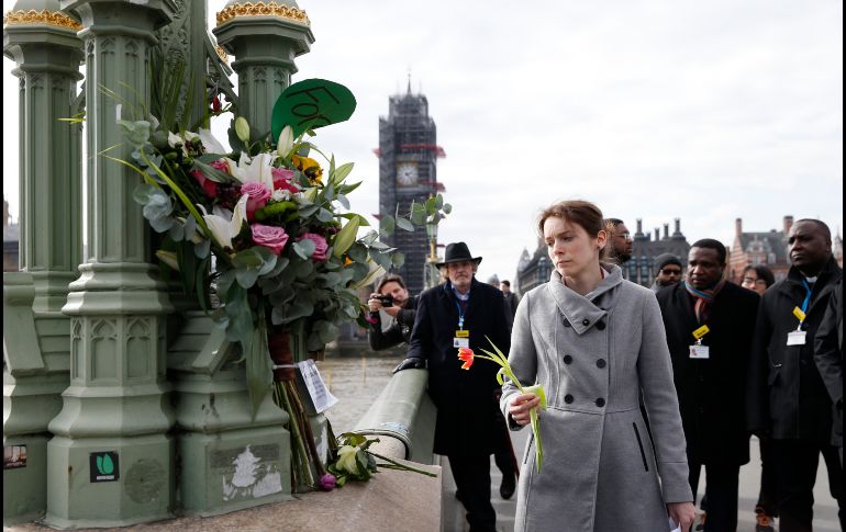 Una mujer deja flores en el puente Westminster de Londres, en memoria de las víctimas del ataque terrorista de hace un año, cuando un hombre arrolló a peatones sobre el puente y luego apuñaló a un policía cerca del Parlamento. AP/A. Grant