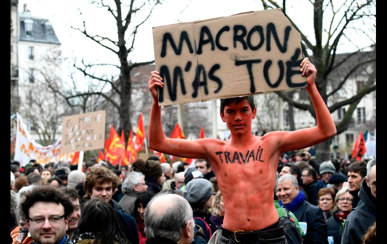 Un joven protesta en París con un cartel en el que se lee: 