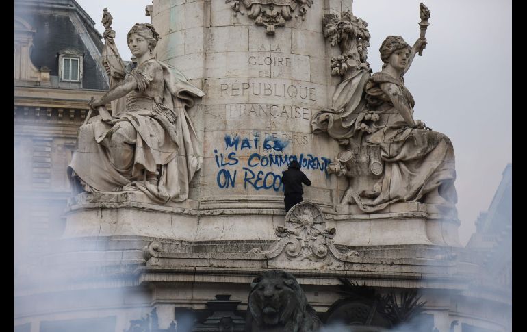 Un hombre vandaliza la estatua en la plaza de la República. Los siete sindicatos eligieron la fecha con el 22 de marzo de 1968 en mente, cuando comenzaron las protestas universitarias que abocaron en las revueltas de mayo de ese año. EFE