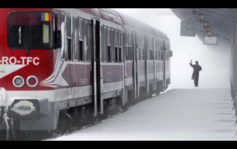 Un trabajador señala la salida de un tren en la estación principal de Bucarest, Rumania. El mal clima provocó la cancelación de trenes y el cierre de escuelas en el sur del país. AP/V. Ghirda