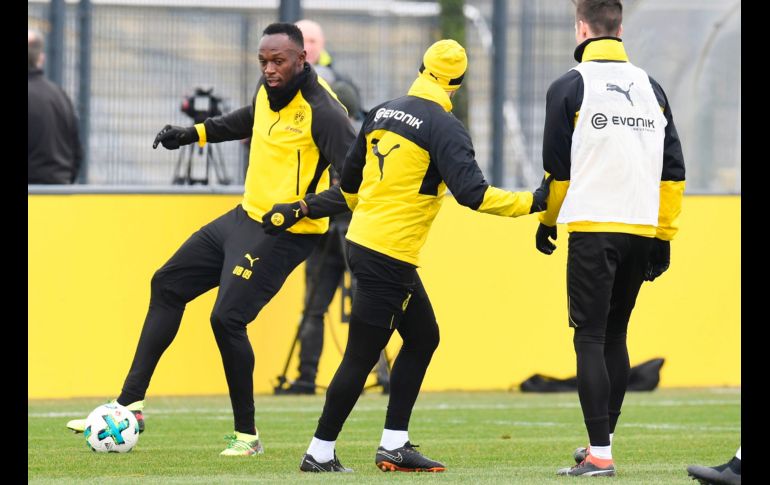 Usain Bolt (i), el ex velocista jamaicano, participa en un entrenamiento del equipo de futbol Borussia Dortmund, en la ciudad alemana de Dormund. Bolt se retiró de las pistas tras el campeonato mundial de 2017. AFP/P. Stollarz