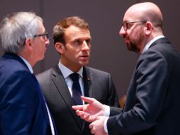 El presidente de la Comisión Europea Jean-Claude Juncker (izquierda), charla con el presidente francés, Emmanuel Macron (centro), y con el primer ministro belga, Charles Michel, durante la cumbre de la UE. AFP/O. Hoslet