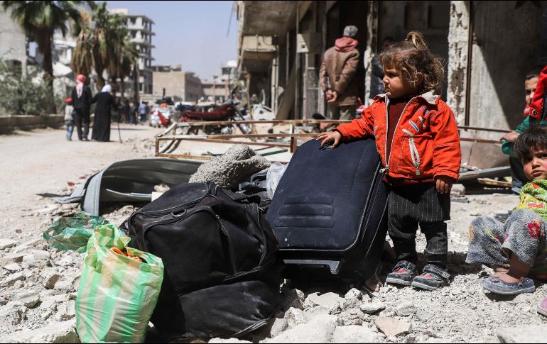 Niños aguardan para ser evacuados de la ciudad siria de Arbin, luego de un acuerdo con el régimen. AFP/A. Almohibany