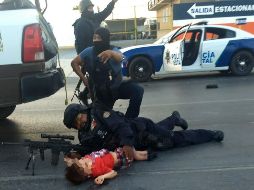 Policías protegen a un niño en medio del tiroteo. EFE/El Mañana