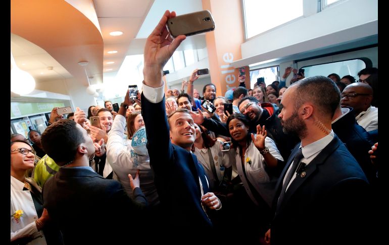 El presidente de Francia, Emmanuel Macron, se toma una foto con trabajadores, durante una visita al hospital del Instituto Curie en París. AFP/B. Tessier