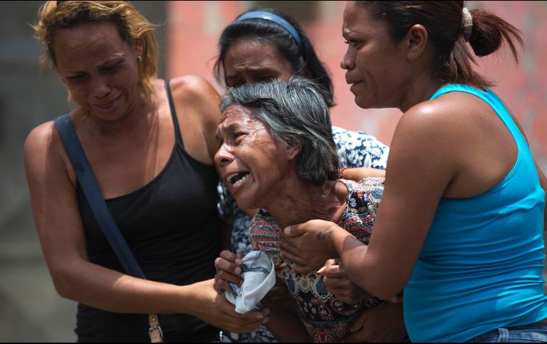 Mujeres reaccionan tras confirmarse la muerte de sus familiares en una comisaría de Valencia, Venezuela. Un incendio desatado ayer en las celdas del lugar dejó 68 muertos. AP/A. Cubillos