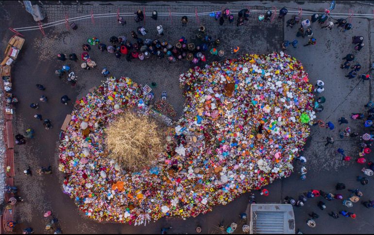 Vista aérea de flores, muñecos y otros objetos colocados en Kemerovo, Rusia, en homenaje a las víctimas del incendio en un centro comercial de la ciudad, el cual dejó 64 muertos. AFP/D. Serebryakov
