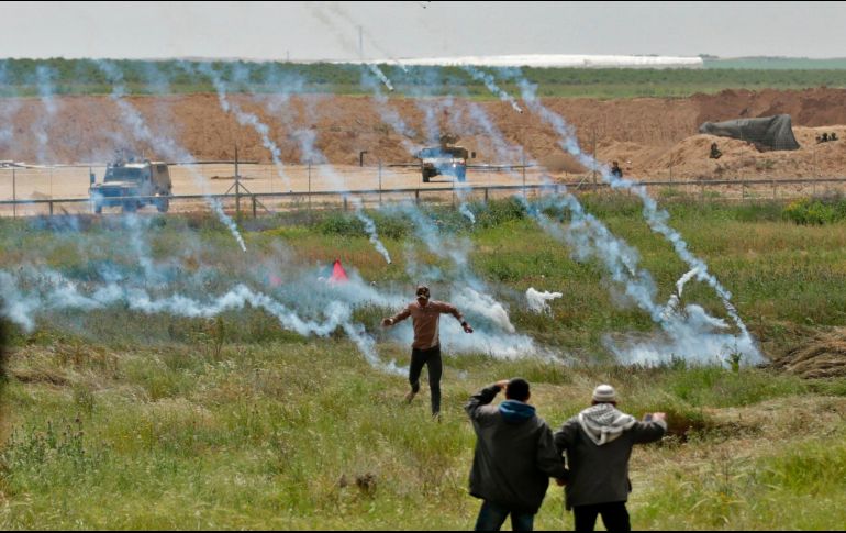 Palestinos huyen del gas lacrimógeno, en el marco de una manifestación por el Día de la Tierra en la Ciudad de Gaza, cerca de la frontera con Israel. AFP/M. Hams