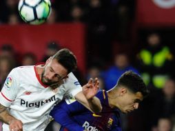 Layún (I) disputa un balón por aire con Philippe Coutinho (D), del Barcelona. AFP/C. Quicler