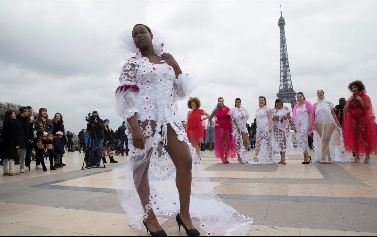 Modelos de tallas grandes posan frente a la torre Eiffel de París, en el marco de evento de modelaje que promueve la diversidad. AFP/T. Samson