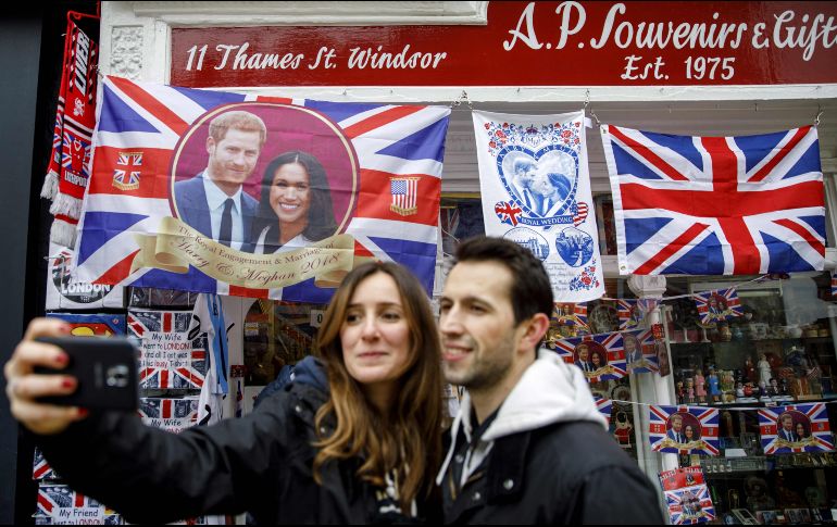 Turistas se toman una foto frente a recuerdos alusivos a el príncipe Enrique y su novia Meghan Markle en una tienda en Windor, Inglaterra. AFP/T. Akmen