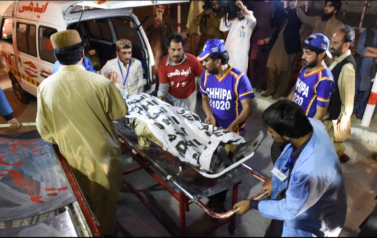 Paramédicos y voluntarios ayudan en el transporte de uno de los cuerpos a la morgue. AFP/B. Khan