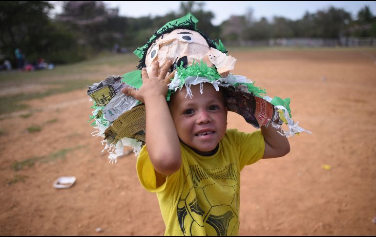 Un niño centroamericano juega con los restos de una piñata. Tras reportes de medios estadounidenses de derecha, Trump arremetió contra la caravana en los últimos días. AFP/V. Razo