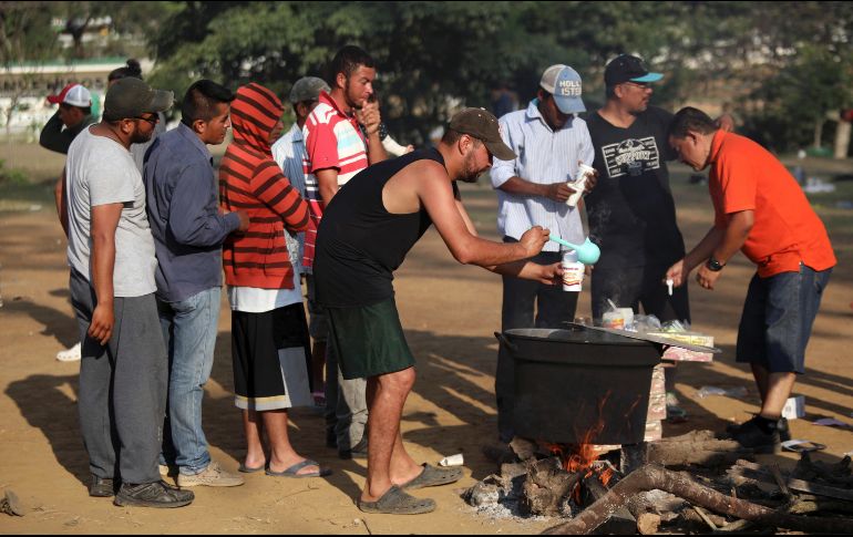 Un hombre añade agua caliente a una sopa instantánea donada. Trump dijo el martes que evalúa desplegar el ejército en la frontera con México para protegerla del paso de migrantes. AP/F. Márquez