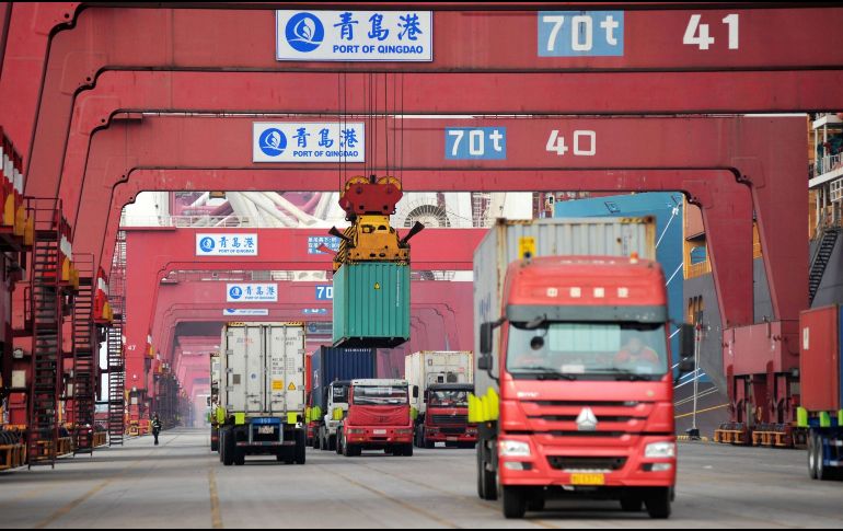Fotografía de archivo del 8 de marzo de 2018 que muestra varios camiones mientras transportan contenedores en un puerto en Qingdao. EFE/Y. Fangping