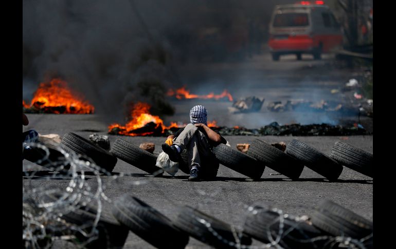 Un hombre palestino quema llantas durante una jornada de protestas en Ramalá, cerc de la frontera de Gaza e Israel. AFP / A. MOMANI