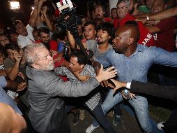 Lula se entrega a las autoridades en medio del tumulto de manifestantes que tratan de evitarlo. EFE / S. Moreira