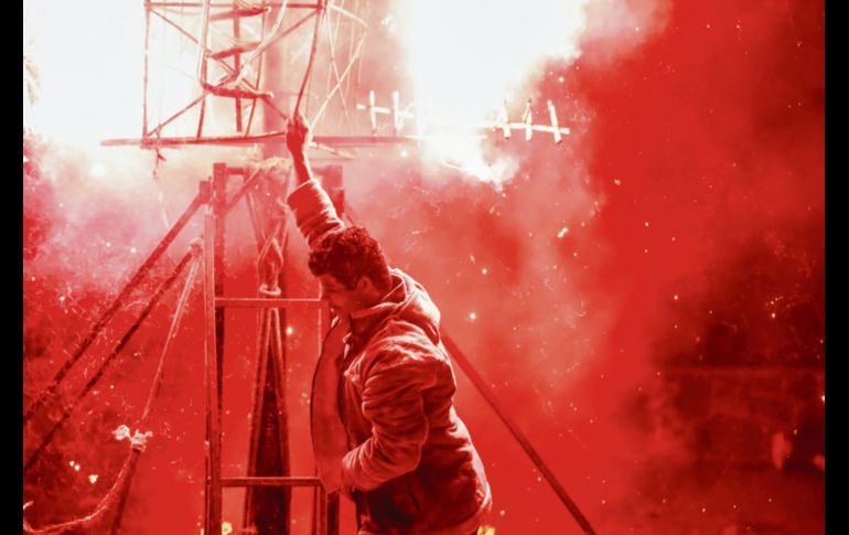 Un hombre sostiene una parte del castillo de pólvora y carrizo con la naturalidad que dan los años de oficio. EL INFORMADOR/ F. Atilano